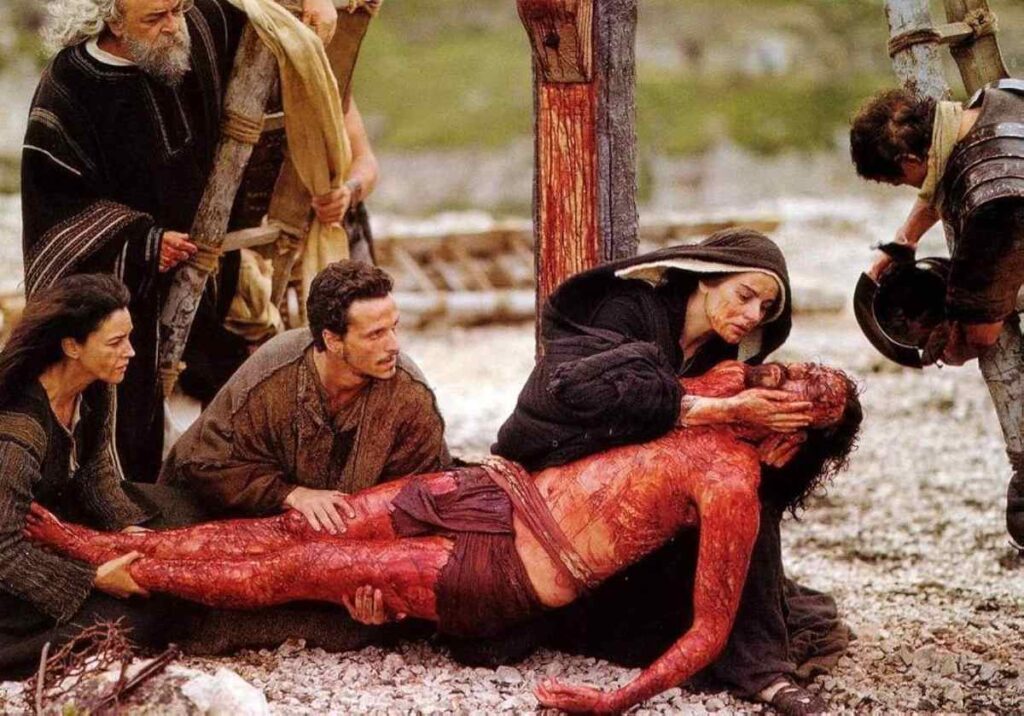 descendimiento-de-jesus-pelicula-la-pasion-de-cristo Descendimiento de Jesús tras la crucifixión, sostenido por María y sus discípulos, escena de la película La Pasión de Cristo.