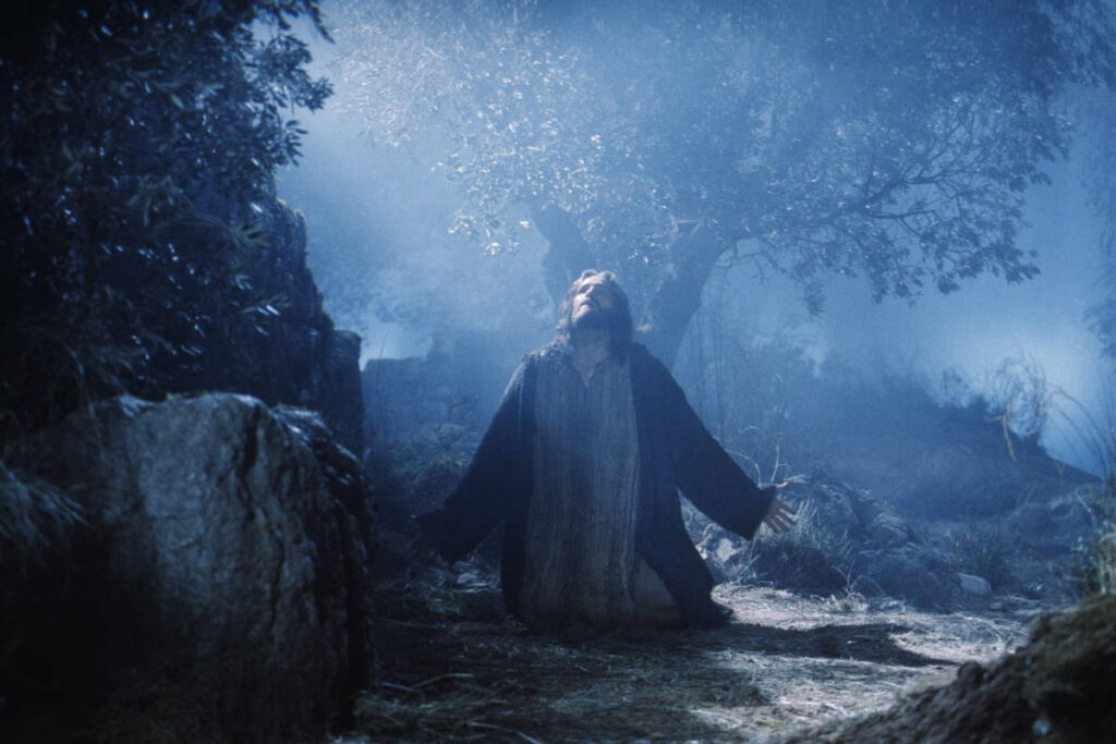 jesus-orando-getsemani-pelicula-pasion-de-cristo Escena de la película La Pasión de Cristo que muestra a Jesús orando de rodillas en el Huerto de Getsemaní durante la noche del Jueves Santo.